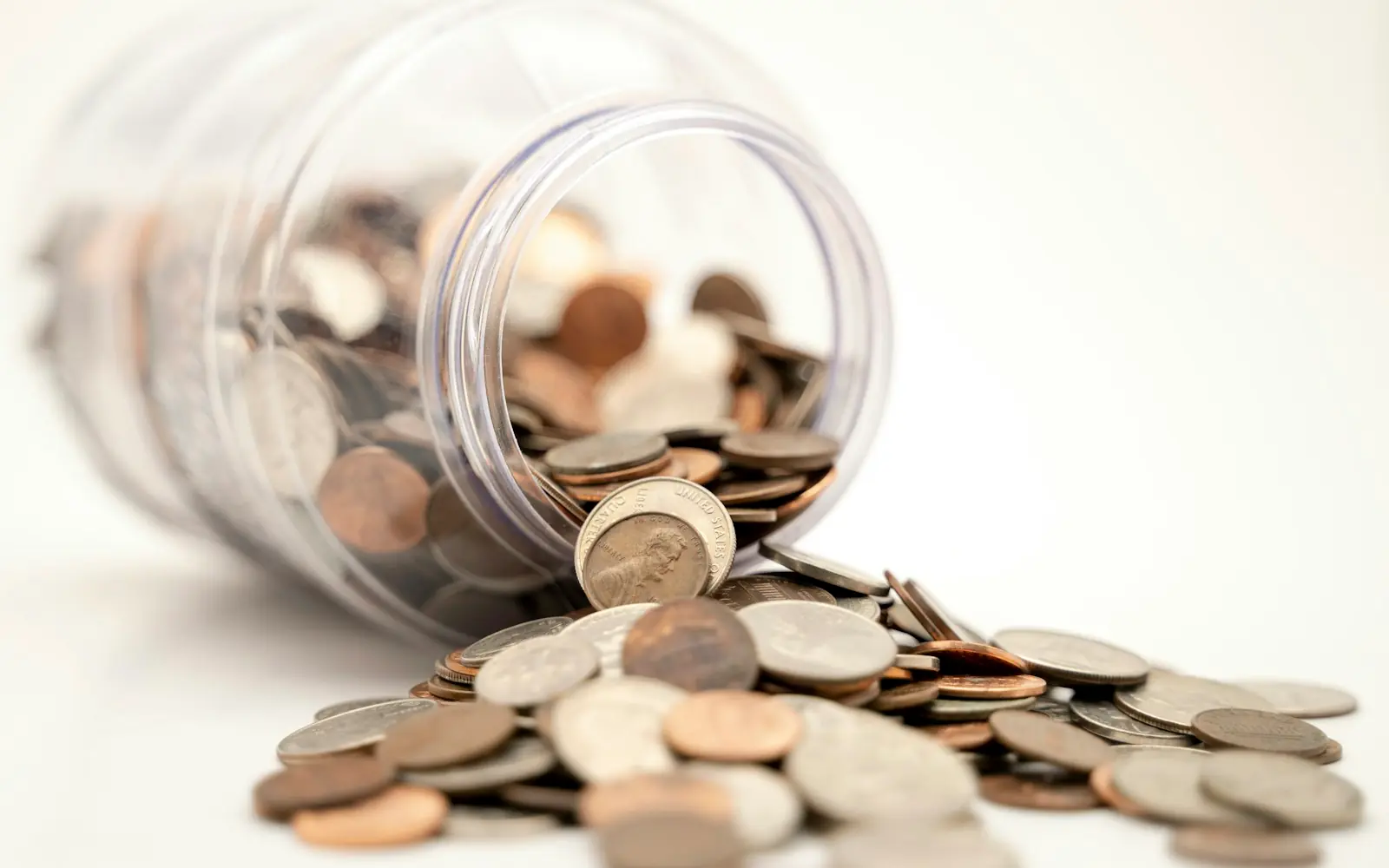 Moedas em pote de vidro representando a captação de recursos para projetos de pesquisa